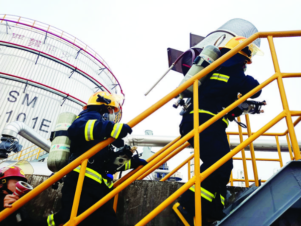     消防隊員扛著泡沫發生器奔向“火場”。