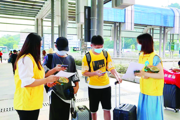 文明交通志愿者在客運場站為乘客提供貼心服務。惠州日報記者張藝明 通訊員林斌 攝