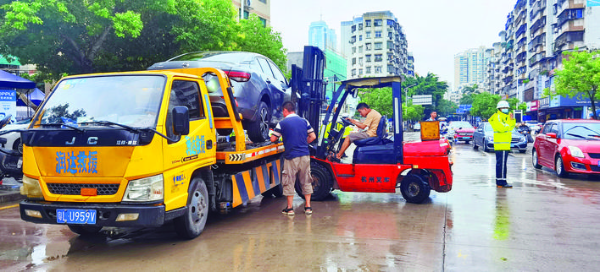 惠州交警依法對違停車輛進行處罰和拖移。